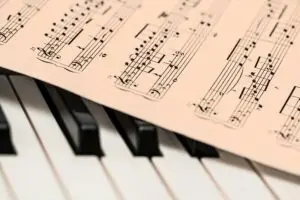Black and white piano keys with a sheet of classical music creating a harmonious composition.